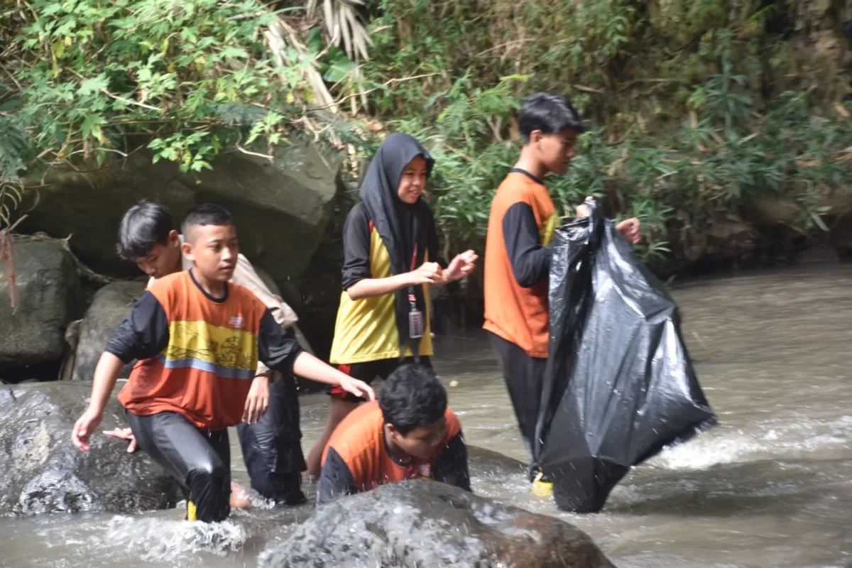 Peringati Hari Lingkungan Hidup, SMP Muhammadiyah 8 Batu Gelar Aksi Nyata Bersih Sungai hingga Sebar Benih Ikan